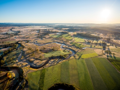 Sun rising over landscape and river 