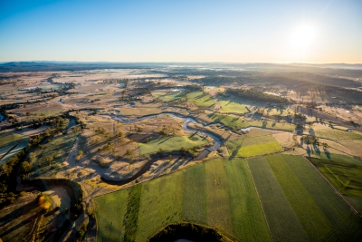 Sun rising over landscape and river 